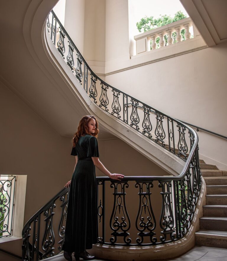 Author K.T. Jay on a grand staircase.